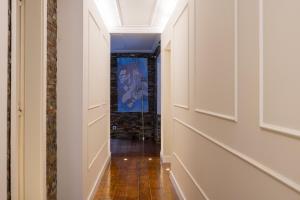 a hallway with white walls and a blue painting on the wall at Charming Apt in Historic House in Coimbra