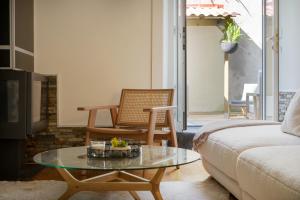 a living room with a coffee table and a chair at Charming Apt in Historic House in Coimbra