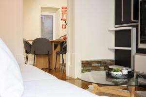 a living room with a glass table and a dining room at Charming Apt in Historic House in Coimbra