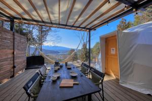 uma mesa e cadeiras num deque com vista em Retreat Camp Mahoroba em Fujikawaguchiko