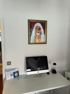 einen Schreibtisch mit einem Computer und ein Bild einer Nonne in der Unterkunft kleines Apartment in Bahnhofsnähe in Erfurt