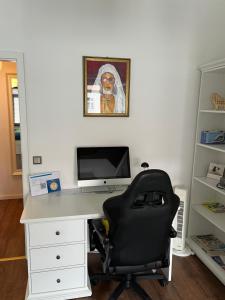 ein Büro mit einem Schreibtisch mit einem Computer und einem Stuhl in der Unterkunft kleines Apartment in Bahnhofsnähe in Erfurt