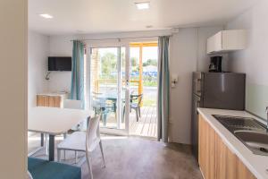 cocina y comedor con mesa y comedor en Camping Marelago, en Caorle