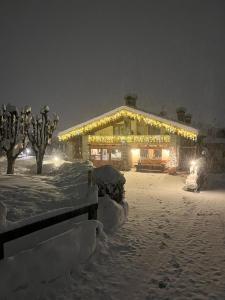 ein Gebäude mit Lichtern im Schnee in der Nacht in der Unterkunft Hotel Lo Campagnar in Courmayeur