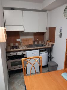 a kitchen with white cabinets and a sink and a table at Residence Sole Dell'Argentario in Porto Santo Stefano