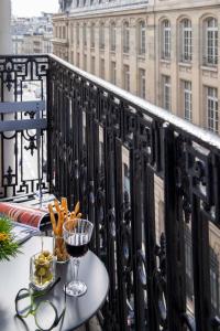 a table on a balcony with a glass of wine at Hotel Phileas Lazare & Spa - Opera in Paris