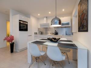 a kitchen with a island with white chairs in it at Traumkoje im Herzen Westerlands strandnah Meer in Westerland (Sylt)