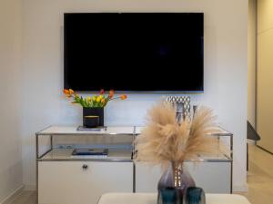 a living room with a tv on a white wall at Traumkoje im Herzen Westerlands strandnah Meer in Westerland (Sylt)