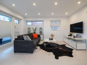 a living room with a couch and a tv at Traumkoje im Herzen Westerlands strandnah Meer in Westerland (Sylt)