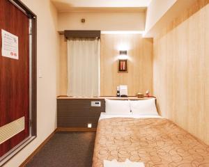 a small room with a bed and a window at HOTEL RELIEF Kokura Station in Kitakyushu