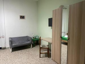 Zimmer mit einem Schreibtisch, einem Stuhl und einem Tisch in der Unterkunft Beteyà Hostel Don Bosco in Catania