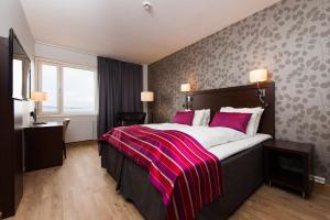 a bedroom with a large bed with a red blanket at Thon Partner Hotel Victoria Hamar in Hamar