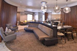 ein Wohnzimmer mit einem Sofa, Tischen und Stühlen in der Unterkunft SpringHill Suites Las Vegas Henderson in Las Vegas