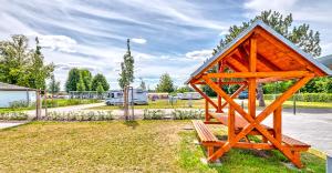 a small wooden structure with a bench in a park at StroamCamp Schwedt - a84456 in Schwedt