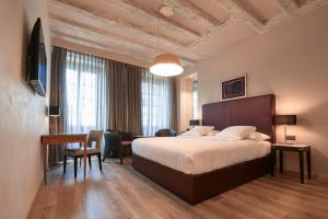 Cette chambre comprend un lit, un bureau et une table. dans l'établissement Hotel d'Allèves, à Genève