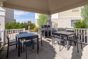 eine Terrasse mit Tischen, Stühlen und einem Grill in der Unterkunft Candlewood Suites Elkhart, an IHG Hotel in Elkhart