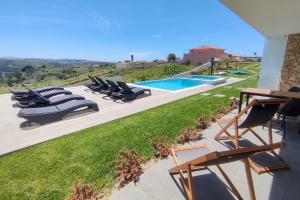 un grupo de sillas sentadas junto a una piscina en Ericeira Surf Apartments, en Ericeira