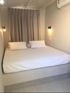 a large white bed with two pillows in a bedroom at Waikiki Apartament Ipanema in Rio de Janeiro