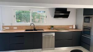 a kitchen with black cabinets and a sink and a window at Rodhes Playa B-1 in Roses