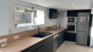 a kitchen with a sink and a refrigerator at Rodhes Playa B-1 in Roses