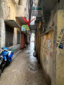 une allée avec un scooter bleu garé dans un bâtiment dans l'établissement Homestay Vũ Miên, Tây Hồ, Ba Đình, à Hanoï