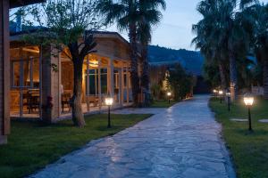 een geplaveide loopbrug voor een huis met verlichting bij Naturelife Bungalows & SPA in Cıralı