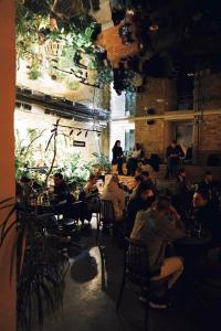 un grupo de personas sentadas en mesas en un restaurante en Globe Runner Hostel, en Kiev