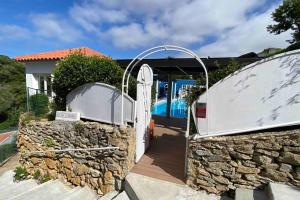 een poort naar een huis met een stenen muur bij Casa Star in Ericeira