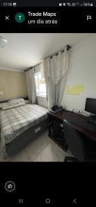 a bedroom with a bed and a desk and a window at Hostel AJBJ Turismo in Curitiba