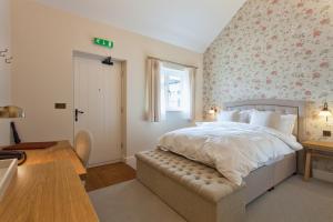 a bedroom with a bed with a floral wall at The Inn West End in Woking