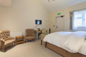 a bedroom with a bed and a table and chairs at The Inn West End in Woking