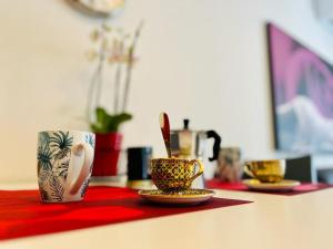 a table with two cups and plates on a table at Grazioso bilocale in centro storico in Verbania