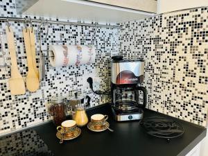 a kitchen counter with a coffee maker and cups on it at Grazioso bilocale in centro storico in Verbania