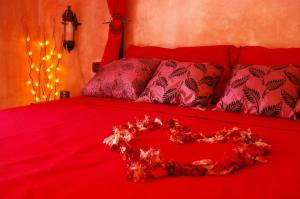 a red bed with a heart made out of flowers at Serapo Bed and Breakfast in Gaeta