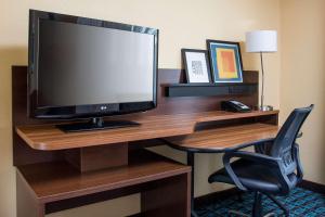 escritorio con TV y silla en una habitación de hotel en Fairfield Inn & Suites Chicago Tinley Park, en Tinley Park