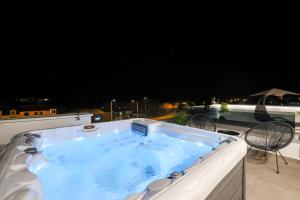 una vasca idromassaggio su un balcone di notte di Leonardo Luxury Residence 2 Penthouse with jacuzzi a Zara (Zadar)