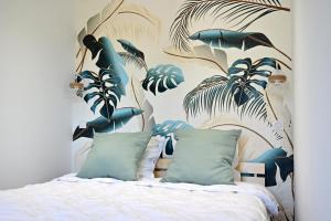 1 dormitorio con 1 cama con un mural de plantas en Appartement Design, en Fréjus