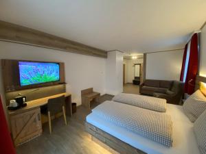 Schlafzimmer mit einem Bett und einem Flachbild-TV in der Unterkunft Hotel-Landgasthof Ploss in Schönwald