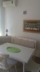 une table blanche avec une plaque verte au-dessus dans l'établissement Apartments Kruno, à Međugorje