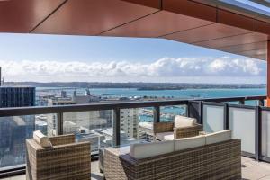 een balkon met stoelen en uitzicht op het water bij City and view holiday home in Auckland