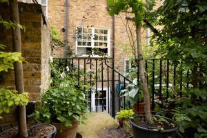 un accès à un bâtiment en briques avec des plantes dans l'établissement Kings Cross, self-contained house & private garden, à Londres