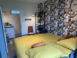 1 Schlafzimmer mit 2 Betten und einer Wand mit Blumen in der Unterkunft B&B slapen in de veenhoop in De Veenhoop