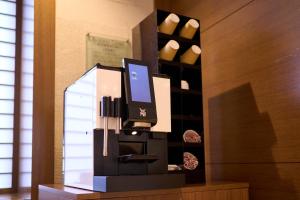 un ordenador en un stand en una habitación con botellas de vino en Hotel Resol Machida, en Machida