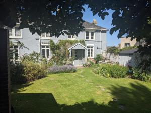 uma grande casa branca com um relvado em frente em Cliffside em Cowes