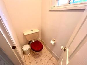 ein kleines Bad mit einem WC und einem roten Sitz in der Unterkunft 3 Bedroom Town house near Gosford CBD Sleeps 6 plus in Gosford