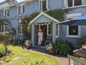 uma mulher de pé na porta de uma casa em Cliffside em Cowes