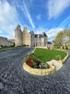 un grand château avec une route en face dans l'établissement Château de Bernesq, à Bernesq