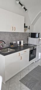 een witte keuken met een wastafel en een fornuis bij GOLD 3 in Sopron