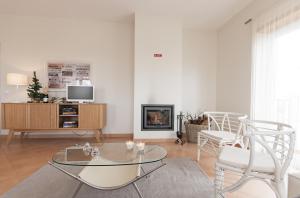 a living room with a table and chairs and a fireplace at Apartamentos Villa T2 Vila Sagres in Sagres