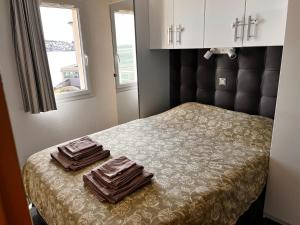 a bedroom with a bed with two towels on it at Une terrasse sur la mer in Crozon